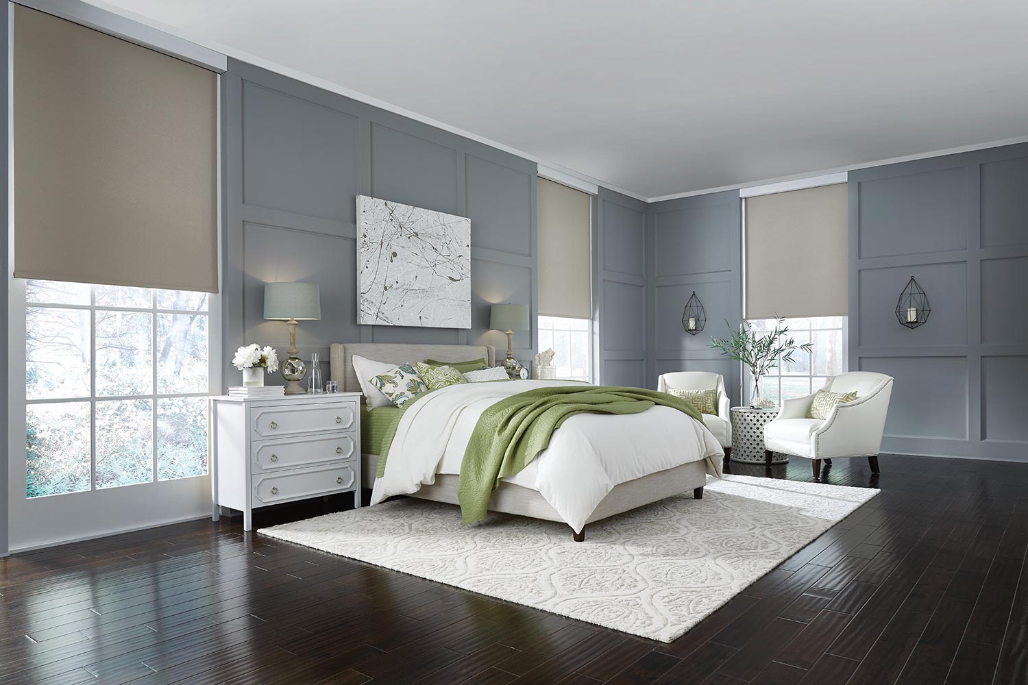 Modern bedroom with white bedding, green accents, upholstered chairs, and large windows filtering natural light.