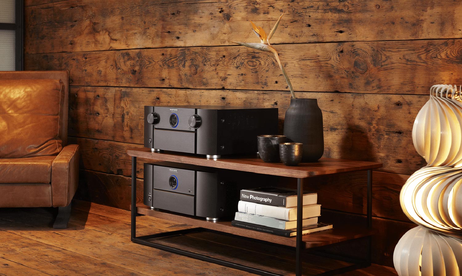 Cozy interior with a leather armchair, wooden media console, audio equipment, and a modern sculptural lamp.