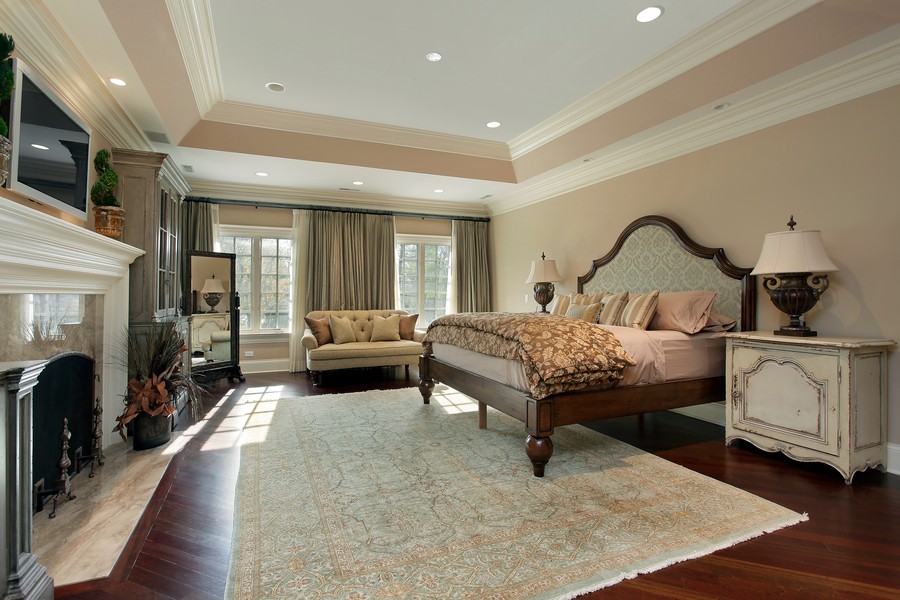 contemporary bedroom with a large bed, a fireplace, and in-ceiling speakers
