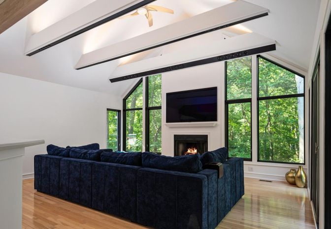 Living Room with white walls and a blue couch and opening in-ceiling speakers